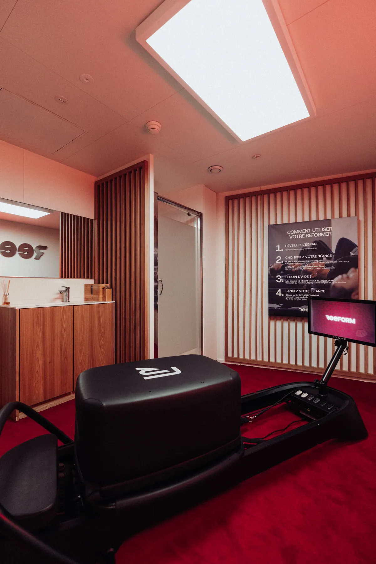 La cabine Capsule REEFORM avec son Reformer et sa moquette rouge